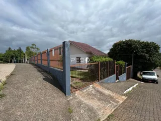 Vista da fachada de uma propriedade em Lajeado, Brasil, com muro e portão.