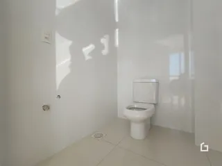 Foto de um ambiente interno mostrando um vaso sanitário branco.