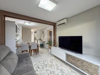 Sala de estar com decoração moderna e piso de porcelanato claro.