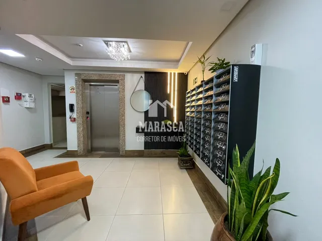 Hall de entrada com piso de cerâmica e móveis na sala.