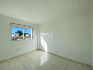 Interior de um cômodo com paredes brancas e piso de cerâmica.