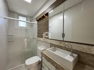 Foto de um banheiro moderno com box de vidro e bancada de mármore.