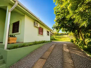 Foto da fachada de uma casa em Lajeado, Brasil, com jardim lateral.