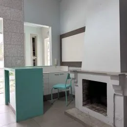 Ambiente interno com parede branca e estrutura de lareira.