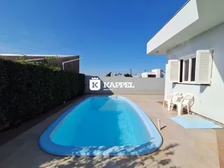 Foto da área externa com piscina e fachada de uma residência em Lajeado.