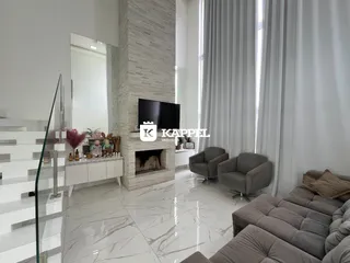 Sala de estar moderna com lareira e grandes janelas.