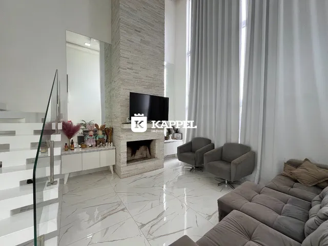 Sala de estar moderna com lareira e grandes janelas.