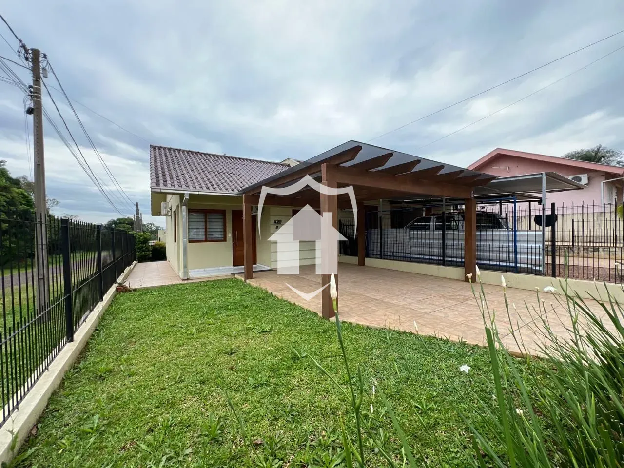 Vista externa de uma residência com cerca e jardim em Lajeado.