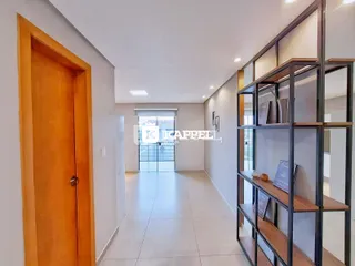 Hall de entrada com piso claro e estante de exposição.