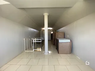 Hall de corredor interno com piso de cerâmica e coluna branca.