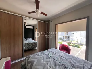 Quarto com armários de madeira e vista para a área externa