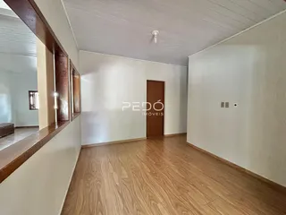 Interior de um corredor com piso de madeira e portas de madeira.