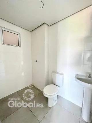 Foto interna de um banheiro com piso de cerâmica e louças brancas.