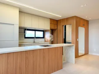 Vista da cozinha moderna com armários de madeira e ilha.