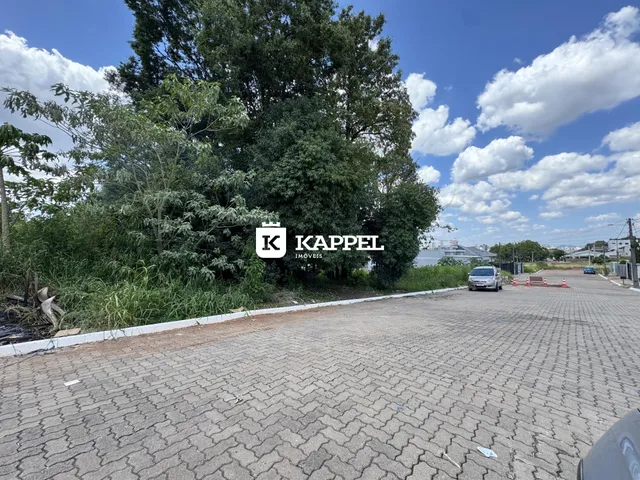 Vista externa de uma área pavimentada com vegetação e uma placa de empresa em Lajeado.