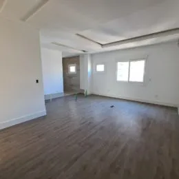 Foto de um ambiente interno amplo com piso de madeira clara.