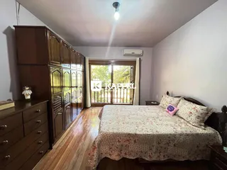 Quarto com armário de madeira e cama em um ambiente claro.