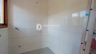 Corredor interno com paredes brancas e piso claro em um imóvel.