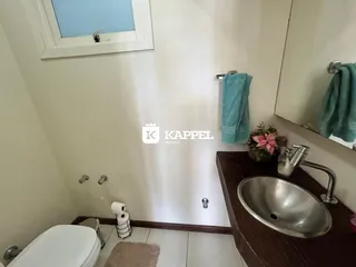 Foto de um banheiro com pia de aço inoxidável e vaso sanitário.