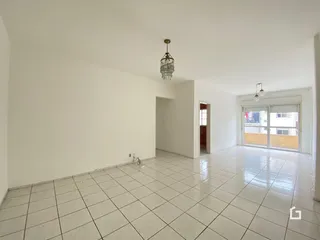 Ambiente interno de uma sala com piso de cerâmica clara e paredes brancas.