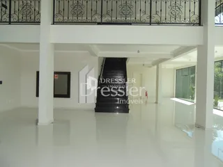 Interior de um espaço amplo com escadaria e varanda em uma residência.
