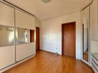 Sala de estar com piso de madeira e portas de madeira na residência.