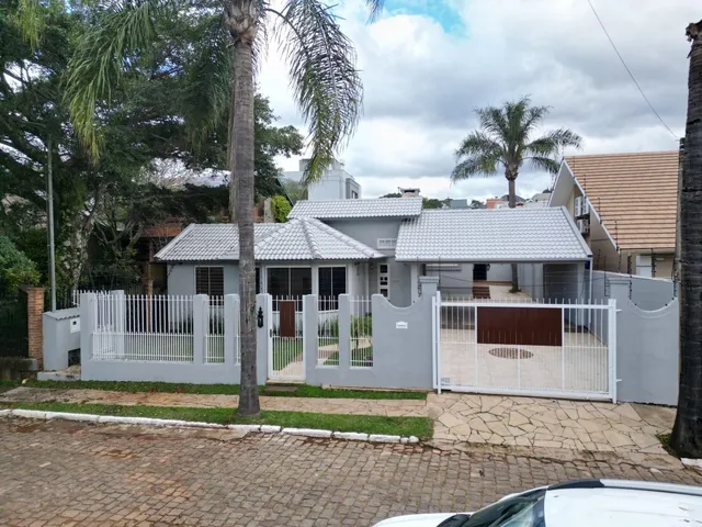 Fachada de uma residência em Lajeado, Brasil, com cerca branca frontal.
