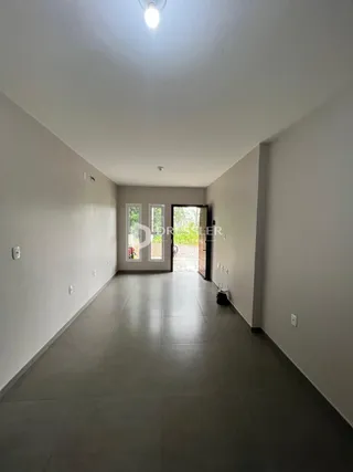 Corredor interno de uma residência com paredes brancas e piso claro.