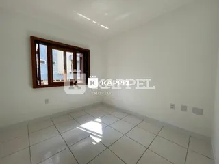 Foto de um ambiente interno com piso de cerâmica e janela de madeira.
