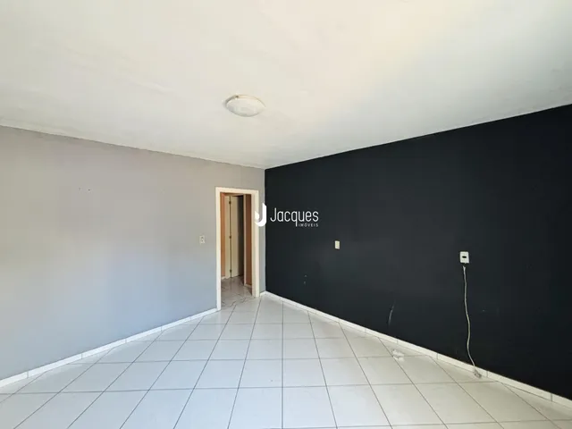 Hall de entrada com paredes cinzas claras e piso de cerâmica branca.