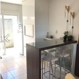 Foto de uma bancada de cozinha com banquetas.