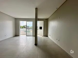 Interior de um espaço aberto com piso de cerâmica e paredes brancas.