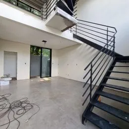 Foto de um espaço interno com escadaria e piso de concreto.
