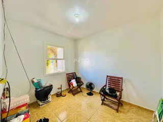 Ambiente interno de uma sala com piso de cerâmica e paredes brancas.
