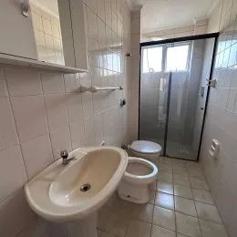 Foto de um banheiro com pia e revestimento de azulejos brancos.