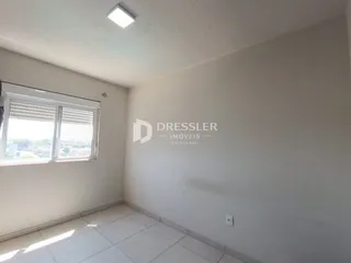 Vista interna de um cômodo com parede branca e piso de cerâmica.