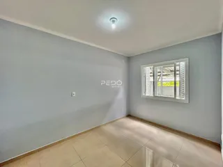 Vista interna de uma sala de estar com piso de cerâmica clara.