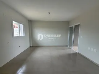 Sala de estar ampla com paredes brancas e piso claro.