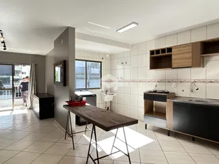 Interior de uma sala de estar com cozinha em um apartamento.