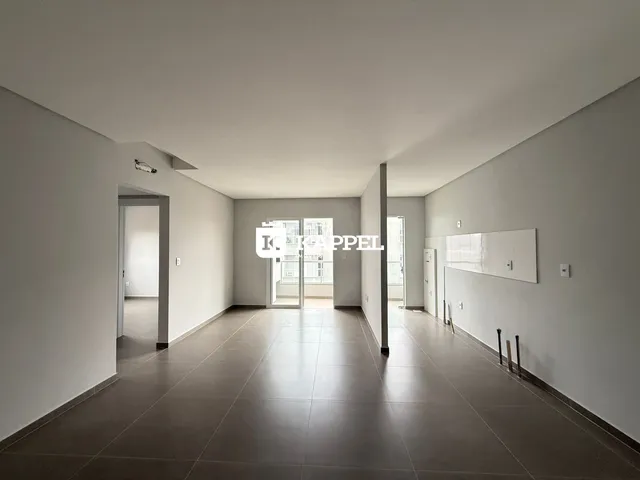 Foto de um corredor interno com piso de cerâmica e paredes brancas.