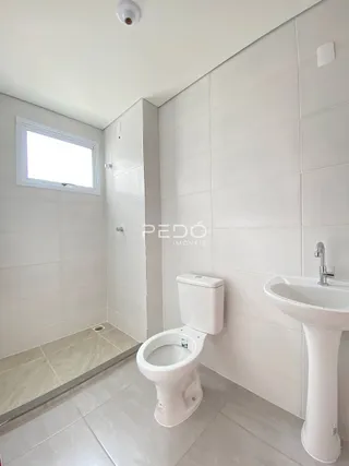 Foto de um banheiro com piso e paredes revestidos de cerâmica.