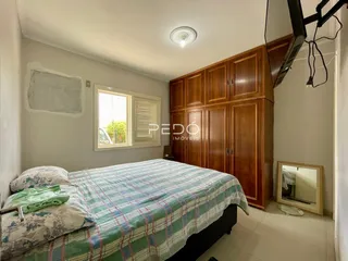 Quarto com cama e armários de madeira em um imóvel no Brasil.