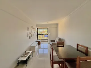 Ambiente interno de uma sala de estar com área de jantar.