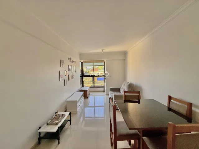 Ambiente interno de uma sala de estar com área de jantar.