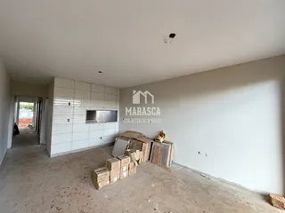 Ambiente interno de uma propriedade em reforma com piso de concreto e caixas de mudança.