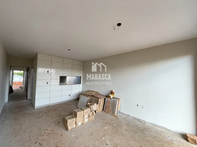 Ambiente interno de uma propriedade em reforma com piso de concreto e caixas de mudança.
