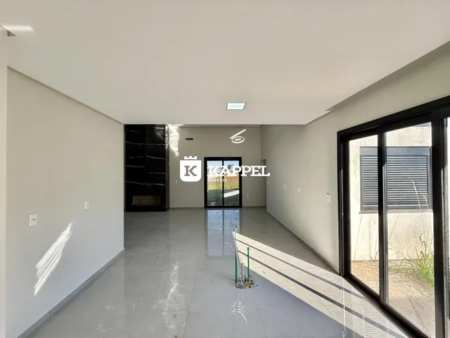 Ambiente interno amplo com piso de concreto polido e iluminação clara.
