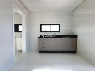 Interior de uma cozinha moderna com paredes brancas e piso claro.