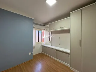 Quarto com paredes azul-acinzentadas e piso de madeira clara.