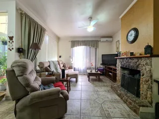 Sala de estar com sofá e lareira em uma residência.